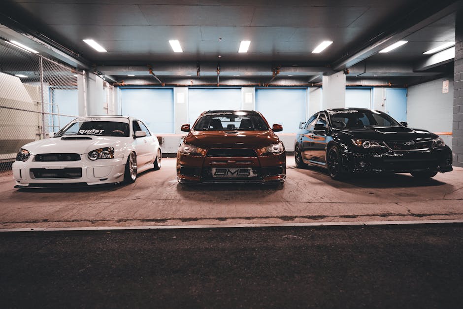 Three sleek sports cars parked side by side in a well-lit urban garage setting